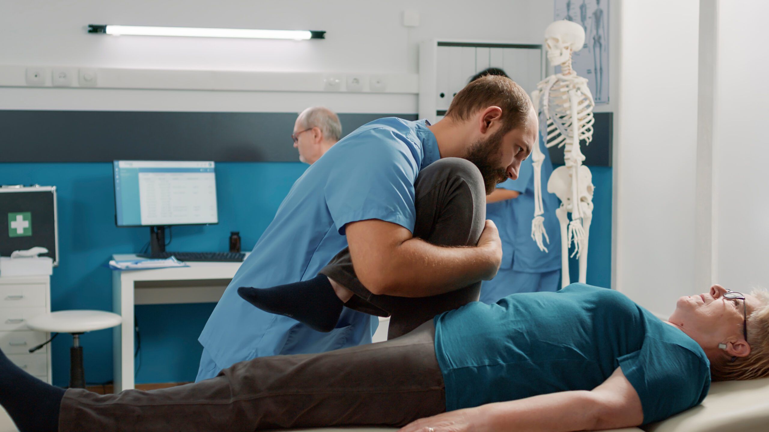 Physiotherapist assisting elder patient with physical injury, giving support at medical procedure appointment. Osteopath and senior woman doing muscles rehabilitation exercise for recovery.