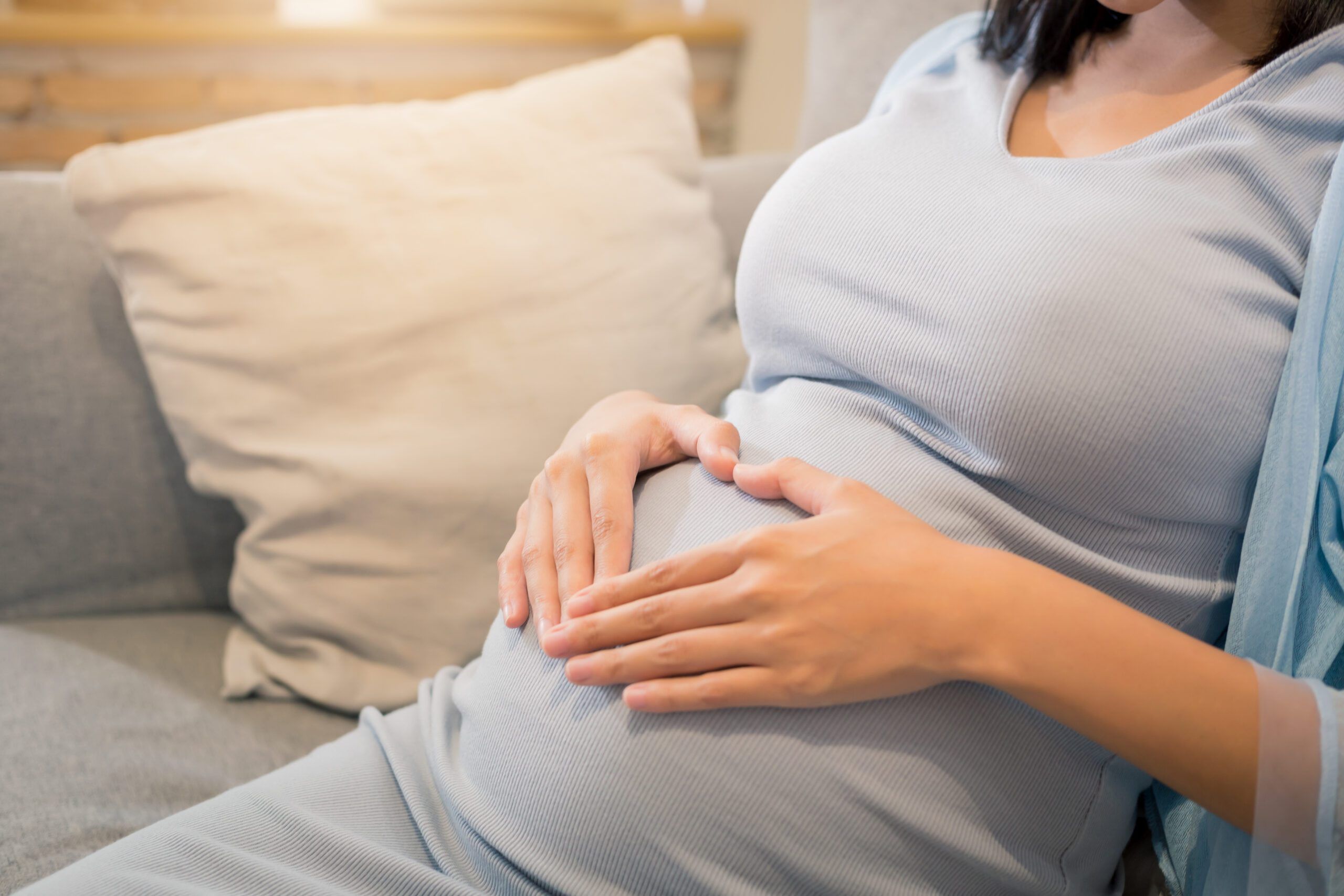 close up of beauty happy Asian pregnant woman with big belly by window - pregnancy, motherhood, people and expectation concept.